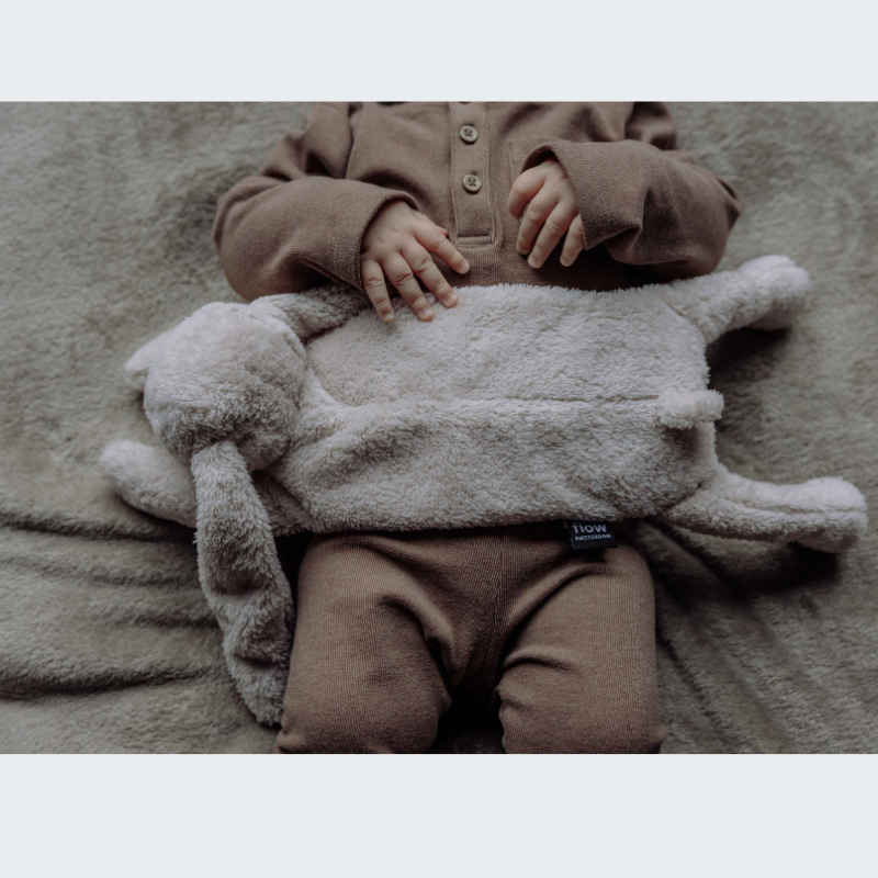 Baby met een beige warmteknuffel op het buikje