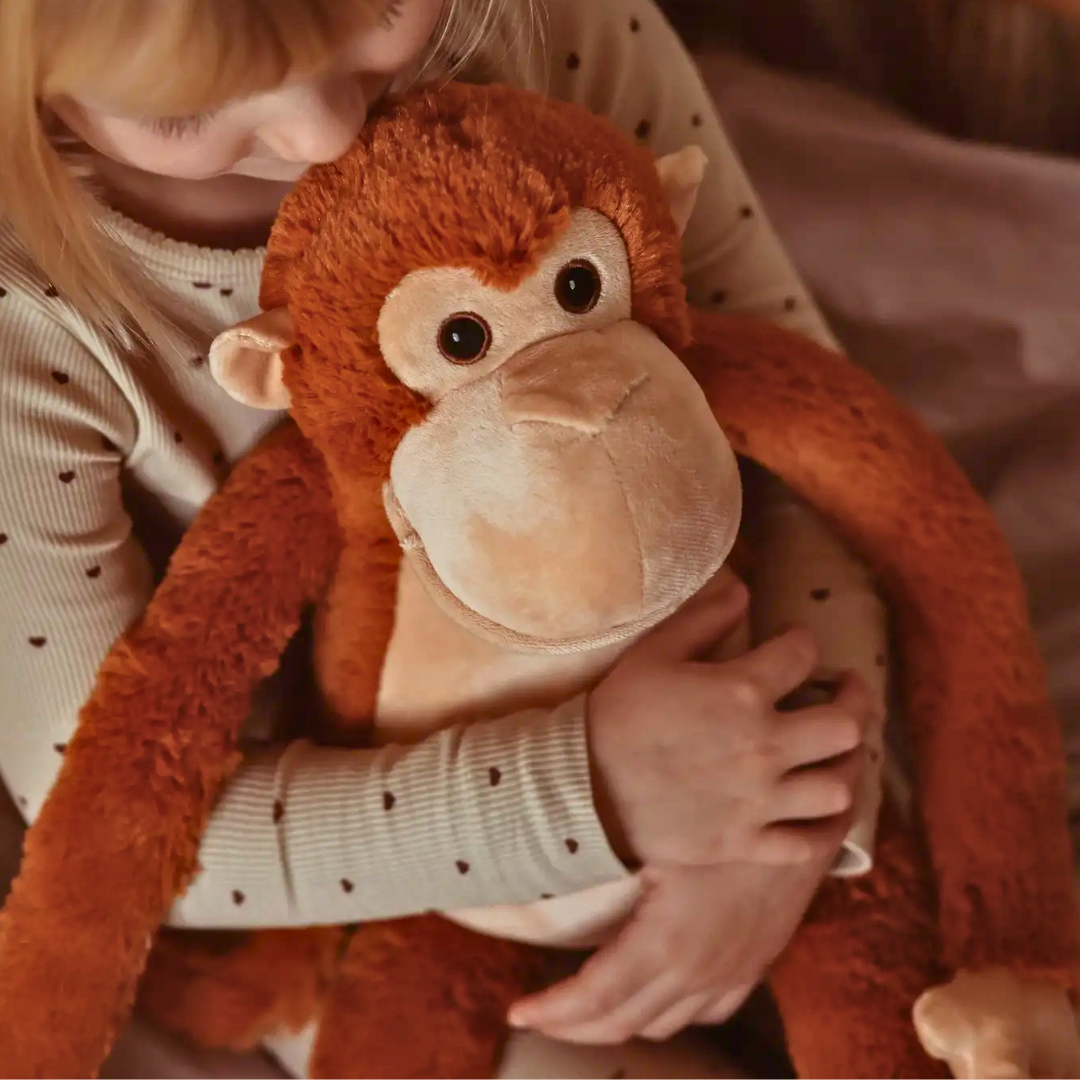 Kindje knuffelt met de verzwaringsknuffel aap. 